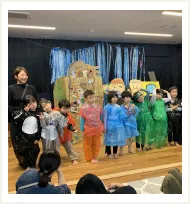 緑の葉を指さす園児たち