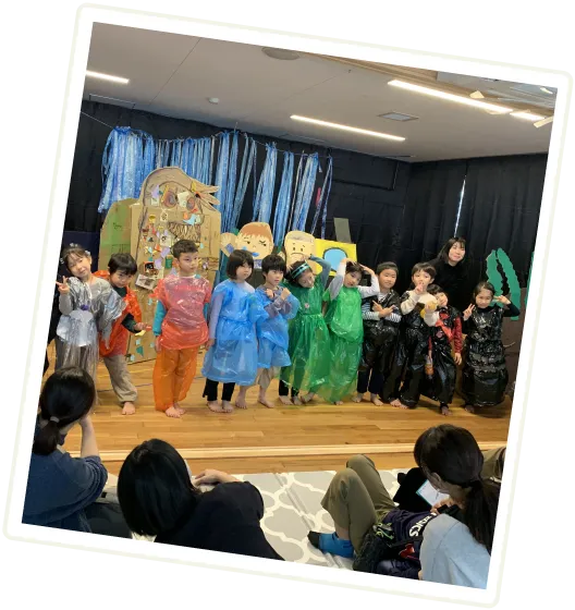 緑の葉を指さす園児たち