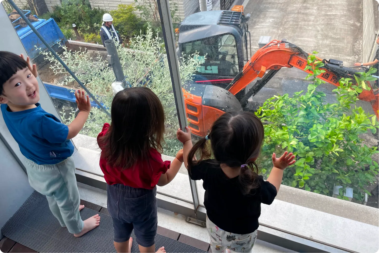 窓から工事を眺める園児たち